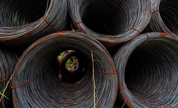 Closeup steel wire coil. Metal steel reinforced for concrete construction. Iron wire for construction industry. Spool or roll of silver steel wire. Metal materials. Rusty steel wire coil.