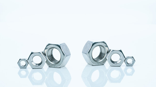 Set of metal hexagon nuts isolated on white background. Small, medium, and big of silver metal hexagon nuts. Hardware tool. Fastener with a threaded hole. Pattern of six metal nuts with copy space.