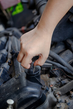 Close up of a  hand of woman is open the engine oil pan cover