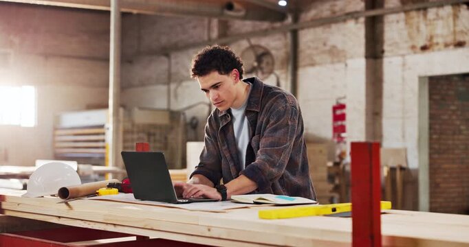 Man, carpenter and reading in factory with laptop, research and review design for production. Person, typing or pc in workshop for carpentry, online blueprint and schedule for manufacturing furniture