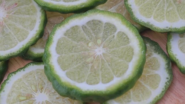 Sliced kaffir lime on wooden board.