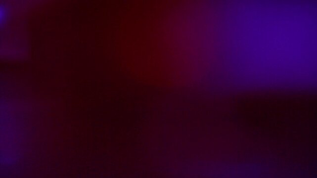 Abstract dark background with soft purple and red light leaks.