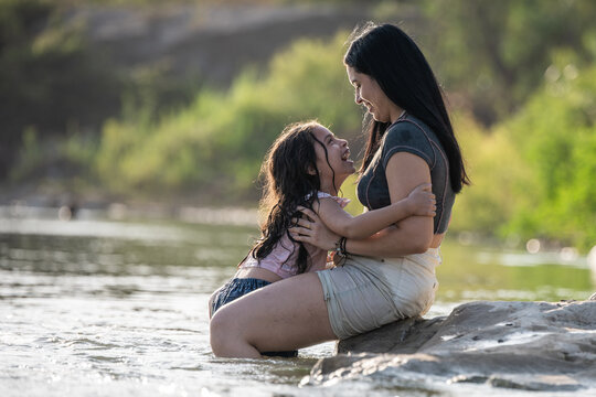 Mother and daughter laughing together in river