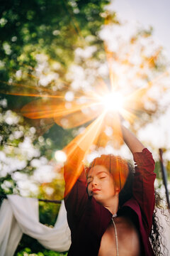 Serene woman with arms raised to the golden sun