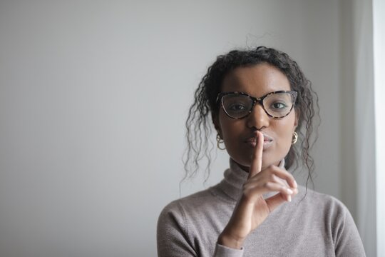 Black woman with finger on lips asking for silence