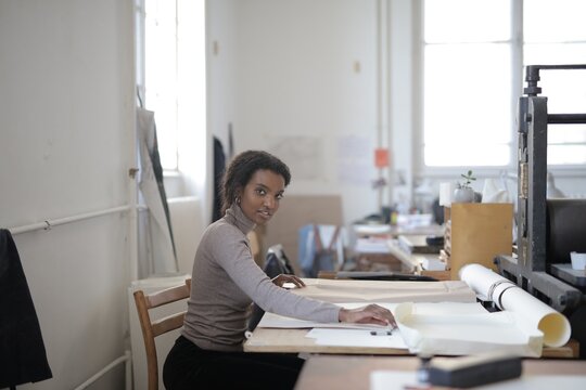 Young Black woman drafting plans in art studio