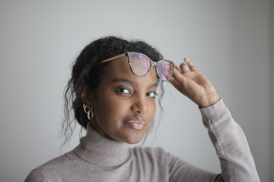 Young black woman lifts glasses to her forehead