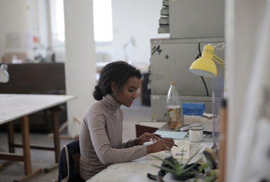 Young Black artist sketching in a creative studio