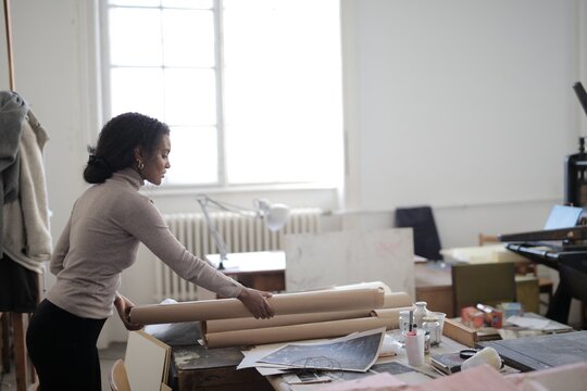Young black artist arranging her work studio