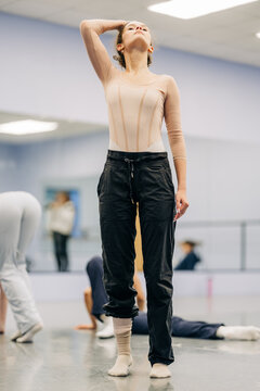 Ballerina stretching neck during dance studio rehearsal