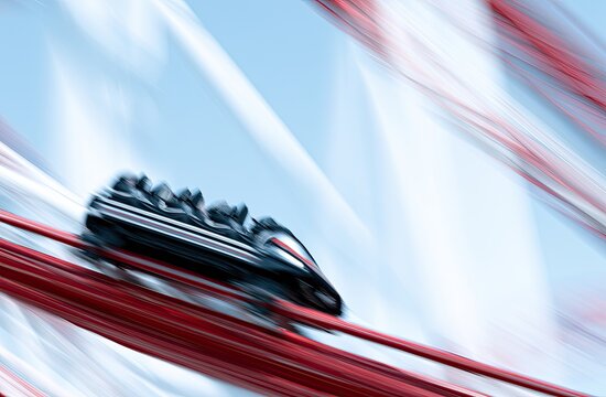 Roller coaster train speeding through abstract, blurred red and white streaks