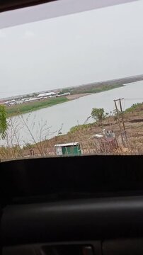 Side view of White Volta River from a moving car window. White Volta flows through northern Ghana from Burkina Faso. A landmark in Yipala, Ghana.