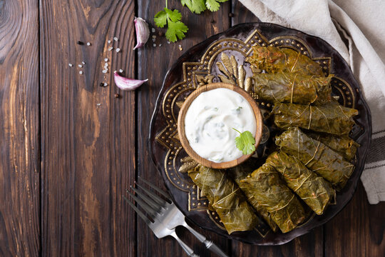 Delicious dolma (sarma), dolmades stuffed grape leaves rice, white yogurt sauce. Mediterranean Dolma. Lebanon turkish greek middle eastern cuisine. View from above. Copy space.