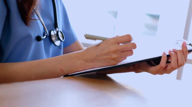 Doctor stethoscope clipboard pen hand medical clinic healthcare uniform writing patient note closeup professional consultation in bright office hospital document detail worker notes