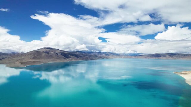 Drone view of Pegu Tso lake or Peikucuo in sunny day in Shigatse, Tibet, China, beautiful peaceful turquoise sea with mountains reflections in Xizang, 4k real time footage travel concept