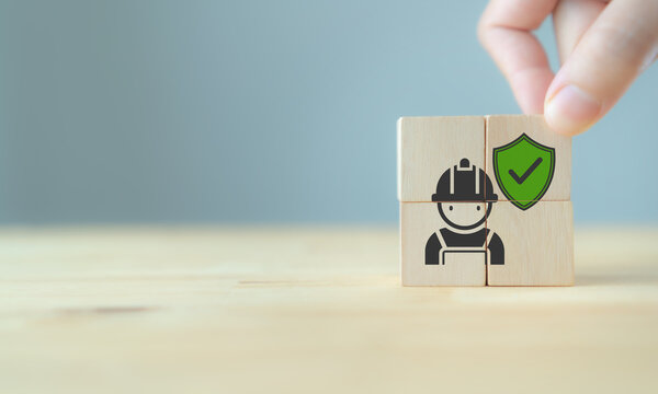 Workplace safety and employee protection concept. Completed a wooden block showing a worker and safety shield. Workplace safety, employee protection, risk prevention, compliance, and safe operations.