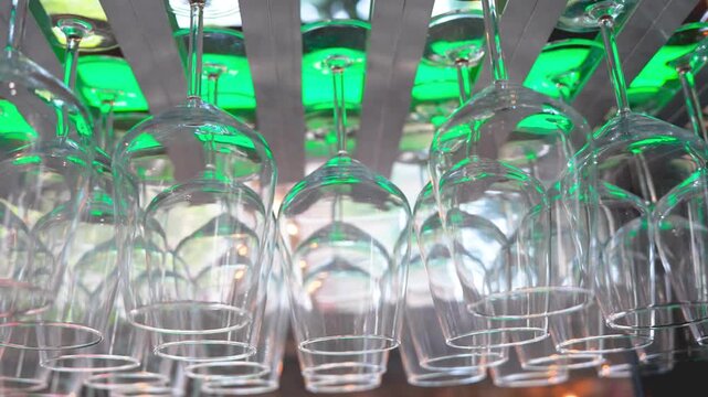 Inverted glasses draining at restaurant after washing in professional kitchen setup