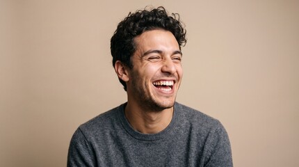 Obraz premium Cheerful young man laughing out loud looking away candid studio portrait