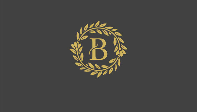 Elegant golden monogram letter B enclosed in a decorative floral laurel wreath over a dark gray background for luxury branding.