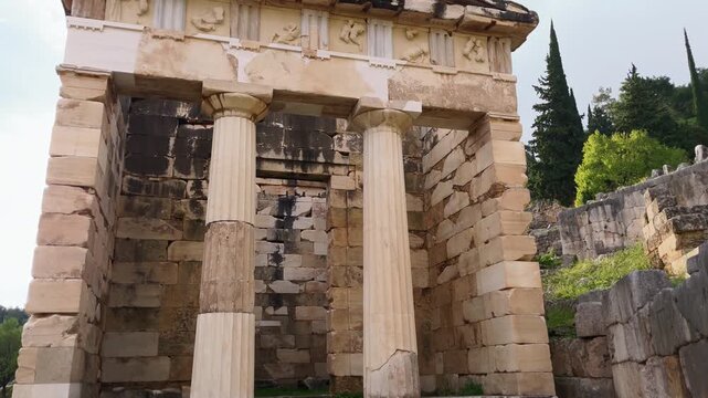 Slow tilt up across ancient stone columns and preserved temple ruins at Delphi, Greece