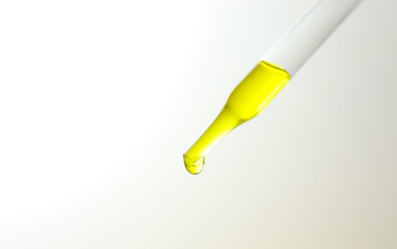 Dripping yellow liquid from pipette on light background, closeup.
