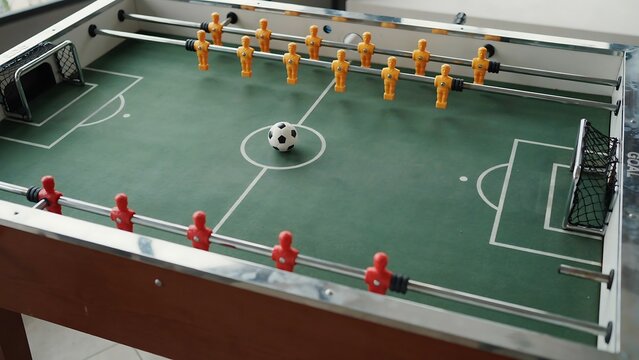 Classic wooden foosball table with players and soccer ball for game