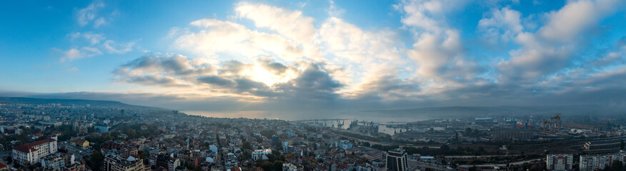 Obraz premium Beautiful high angle panoramic view of Varna city, port, and bay under a cloudy sky at sunrise