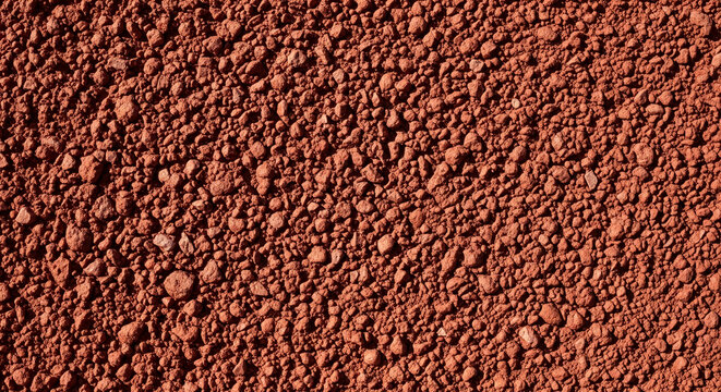 Red clay soil texture, showing granular surface details, representative of natural earth and organic material, perfect for environmental or rustic themes