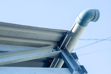 Naklejka premium Modern lightweight steel roof construction with PVC rain gutter installed under clear blue sky.