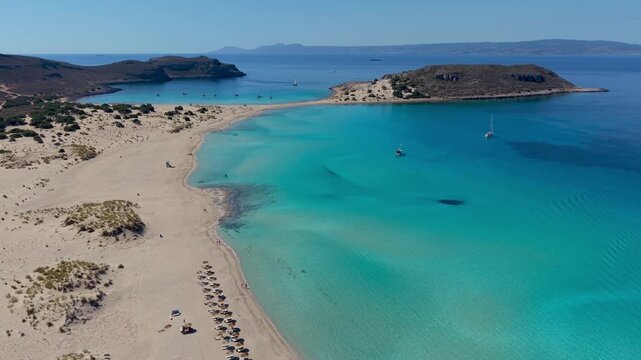 Experience the stunning landscapes of Simos Beach in Elafonisos, Greece, featuring crystal clear waters and soft sands. Enjoy the serene surroundings and vibrant sunsets, perfect for relaxation.