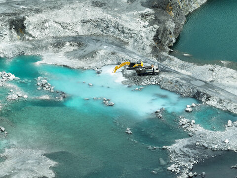 Open pit mine industry. Limestone quarry with backhoe and truck in operation. Heavy machinery in mining industry and construction material supply. Landscape of resource extraction in a industrial site
