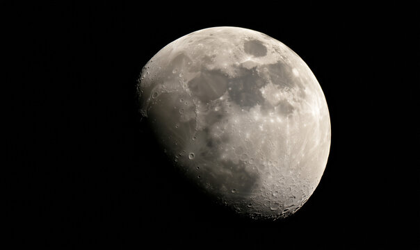 A captivating half moon, with its luminous surface, partially obscured by the darkness of space, showcasing lunar craters.