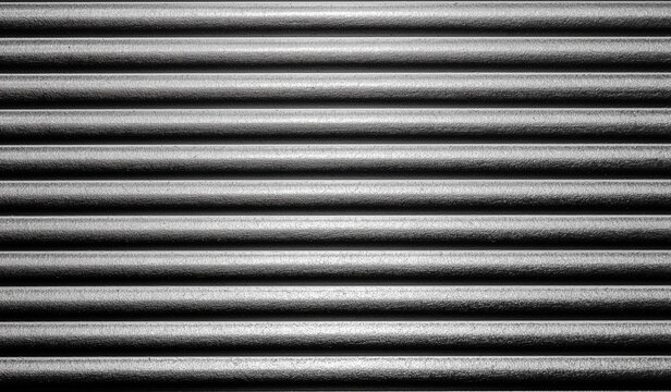 Detailed close up of dark gray corrugated metal surface with parallel horizontal lines creating rhythmic linear pattern design.