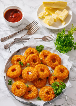 Golden Breaded Cheese Wheels On Paper on a tray