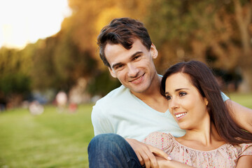 Fototapeta premium Love, relax and smile with couple in park for romance, affection and care together. Summer date, honeymoon and relationship with portrait of man and woman in nature for support, space and happy
