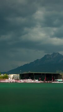 Lucerne Switzerland time lapse of KKL culture convention center and Mount Pilatus with dramatic storm clouds rushing over lake