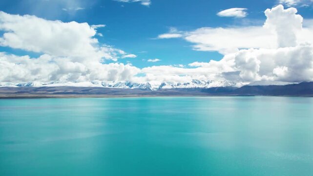 Drone view of Pegu Tso lake or Peikucuo and Mount Shishapangma&zwnj; in sunny day in Shigatse, Tibet, China, beautiful peaceful turquoise sea with snow mountains reflections in Xizang, 4k real time footage
