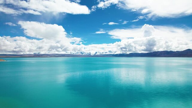 Drone view of Pegu Tso lake or Peikucuo and Mount Shishapangma&zwnj; in sunny day in Shigatse, Tibet, China, beautiful peaceful turquoise sea with snow mountains reflections in Xizang, 4k real time footage