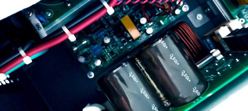 Electronic circuit board with capacitors, wiring, and power components inside modern equipment. Electrical engineering design, industrial hardware technology, and reliable energy control system.