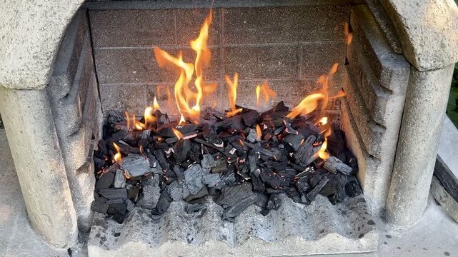 Close-up of Flames Dancing Over Burning Charcoal Briquettes