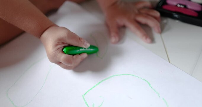 Child coloring with crayons on paper, art activity, creativity, early childhood education, learning, imagination, and child development, close-up