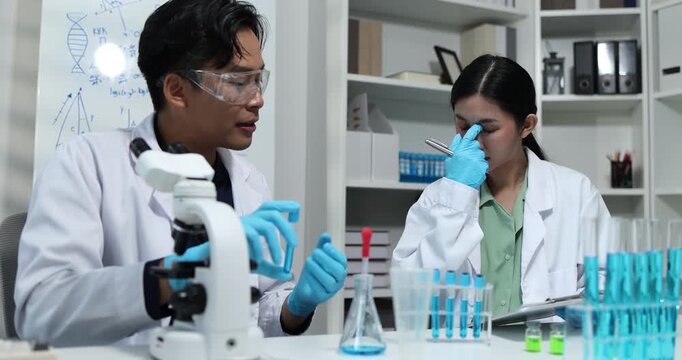 Scientists collaborate in a modern laboratory, analyzing samples with microscopes, pipettes, and test tubes while conducting biomedical research, scientific testing, and laboratory experiments.