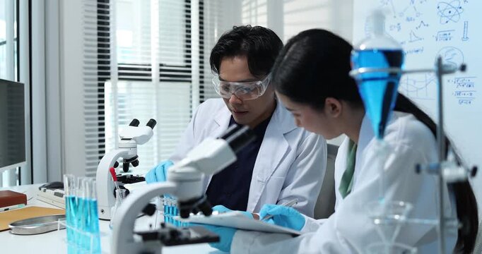 Scientists collaborate in a modern laboratory, analyzing samples with microscopes, pipettes, and test tubes while conducting biomedical research, scientific testing, and laboratory experiments.