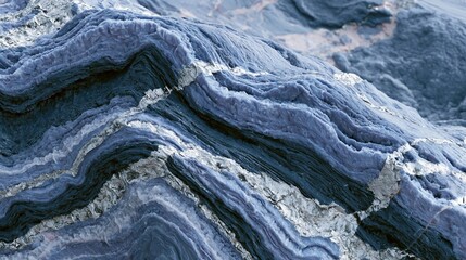 Fototapeta premium Close-up of a rock surface with a wave-like pattern. the rock appears to be made up of different shades of blue and gray, with some areas appearing darker and others lighter.