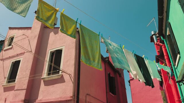 Colorful Burano houses with laundry under blue sky