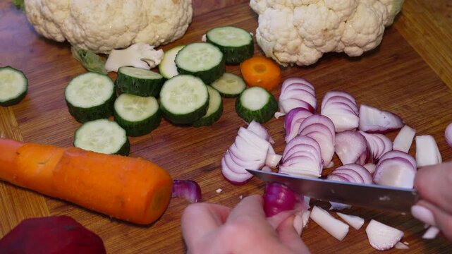 Onion cutting cooking, professional chef slicing fresh red vegetable on wooden board for healthy meal preparation in home kitchen environment close up