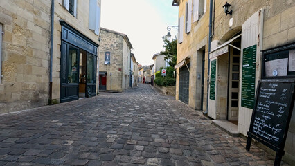 Fototapeta premium Quiet Cobblestone Street with Historic Architecture in Castillon-la-Bataille France