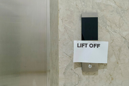 Broken elevator out of service sign with text Lift Off taped over control panel in a modern residential or commercial building hall.Building maintenance. Accessibility and repair concept.