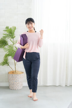 ガッツポーズするヨガウェアの若い女性