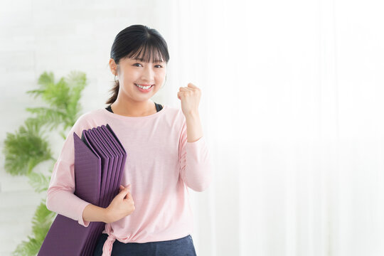 ガッツポーズするヨガウェアの若い女性